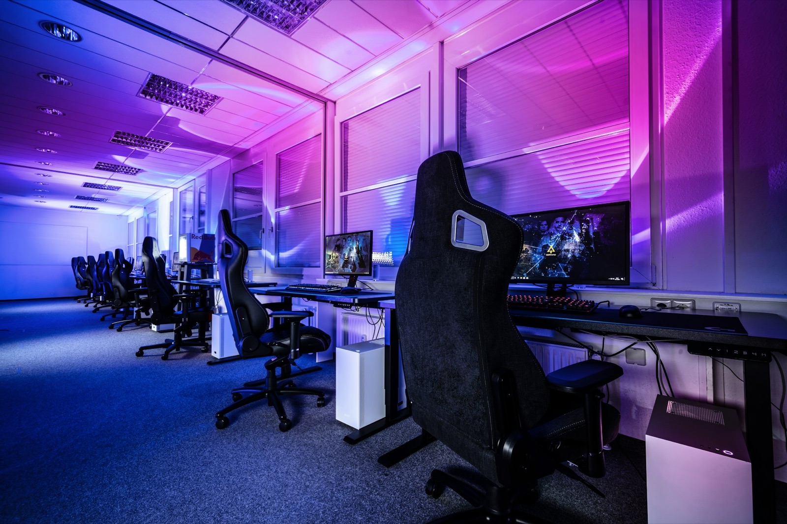 Sala tornei esports con postazioni gaming e luci neon viola