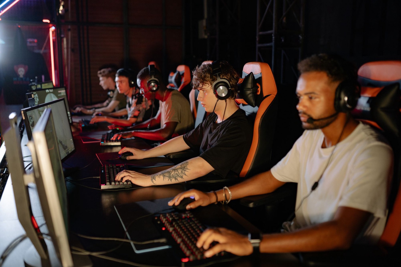 Giovani si sfidano in un mini-torneo su postazioni gaming illuminate al neon